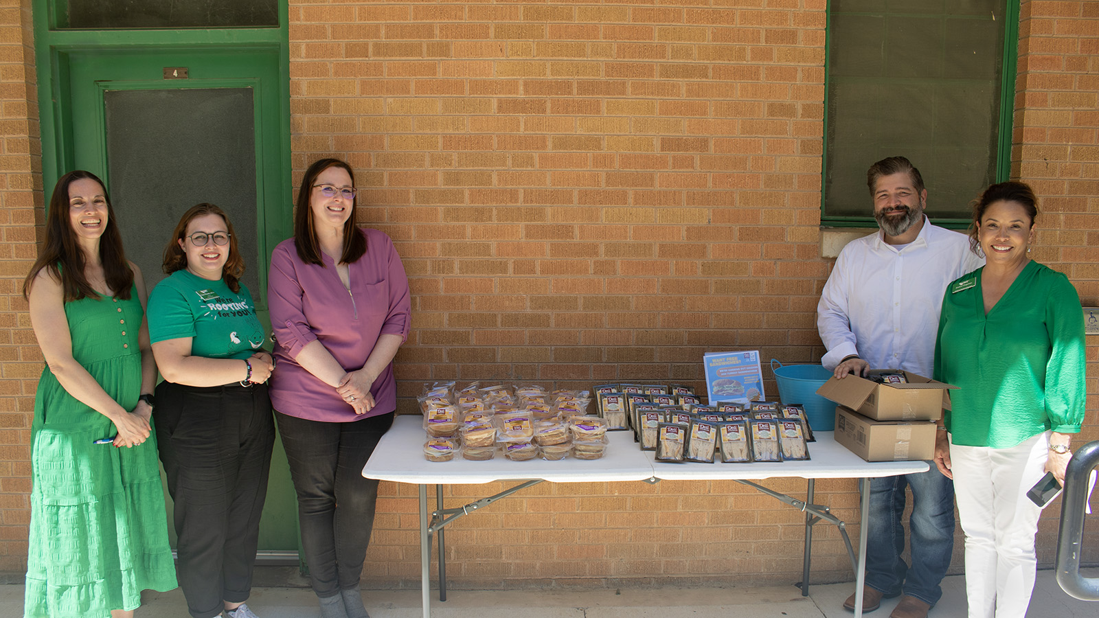 UNT Dean of Students Laura Smith, Tristen Wheeler, Meagan Kirkham, Jeff Trevino and Jessica Chapman, senior director of corporate and foundation relations, distribute sandwiches to students at the UNT Food Pantry