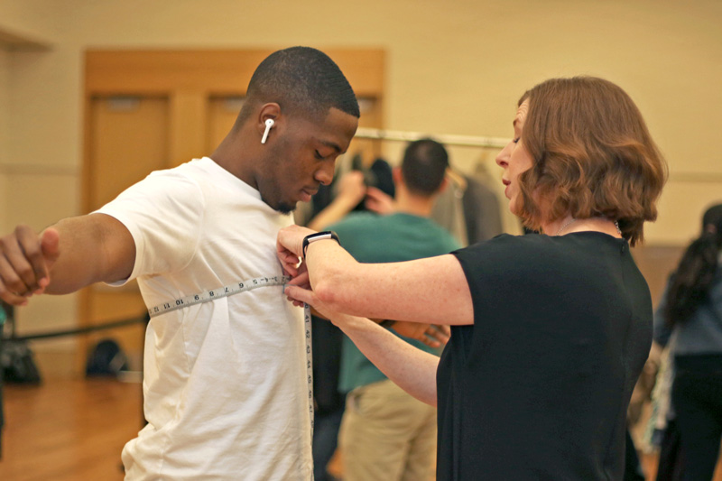 A student is measured for a suit at a Suit Up event on campus.